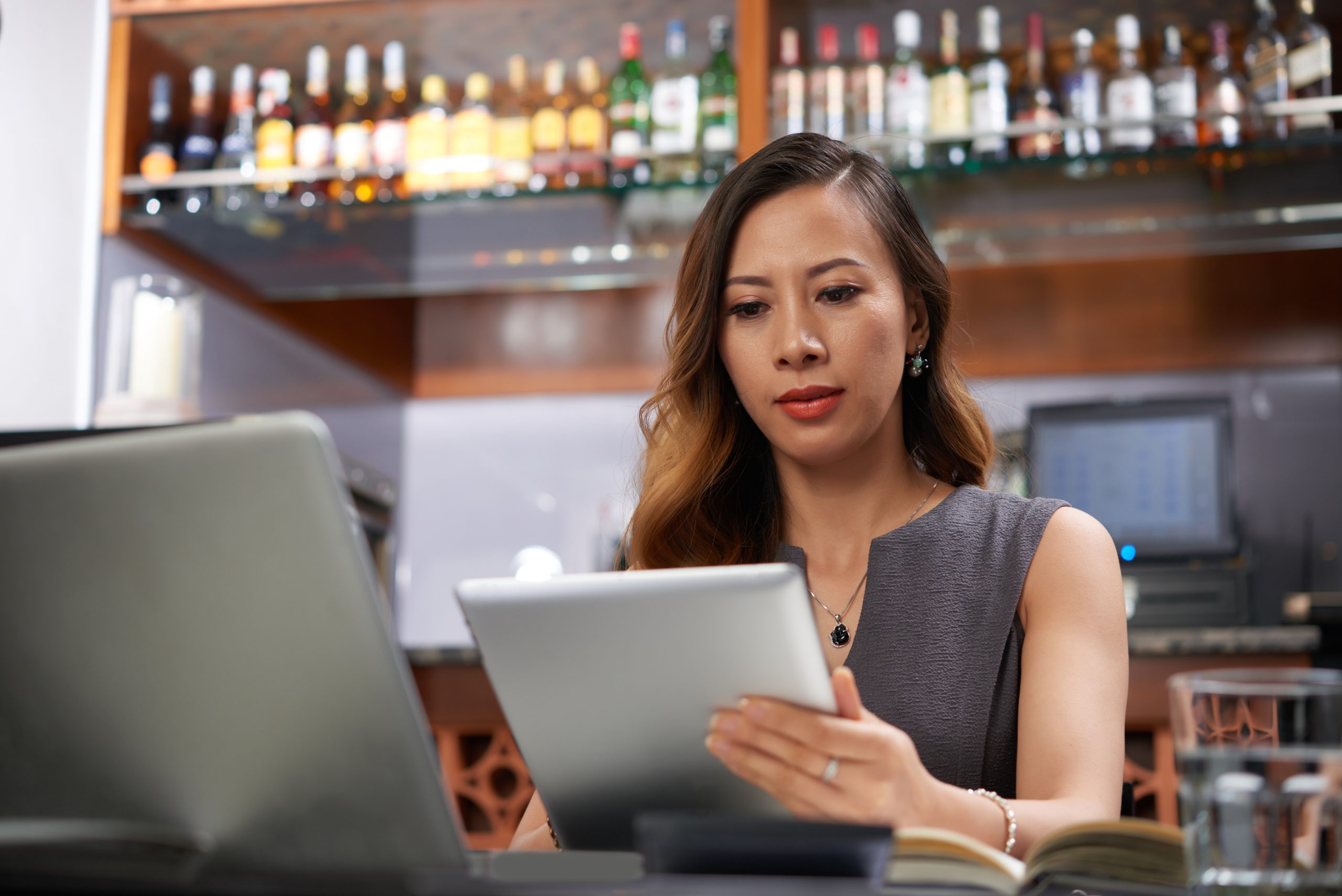 Female bar owner with tablet computer working